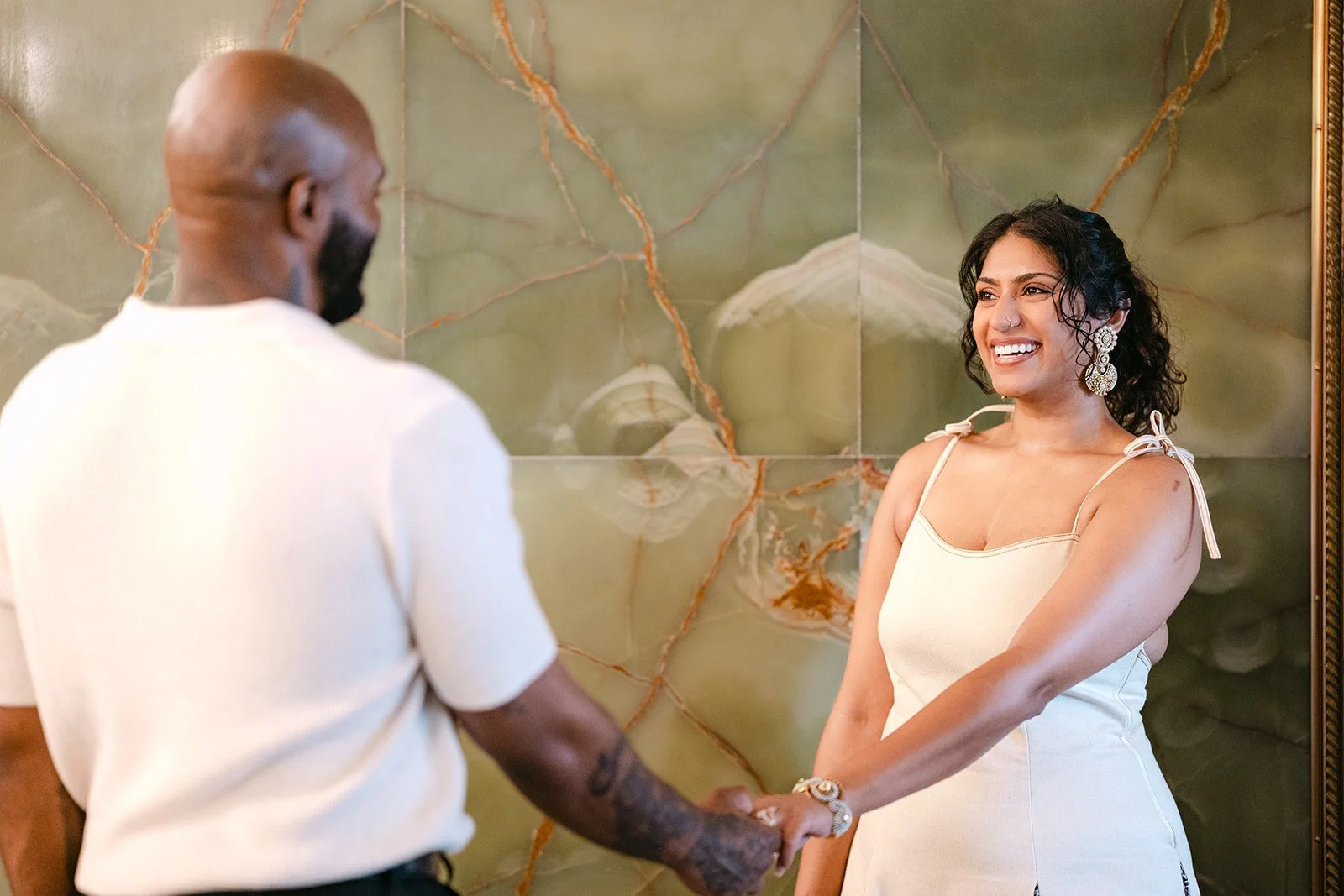 Couple holding hands inside Fisher Building for their Detroit engagement photos.