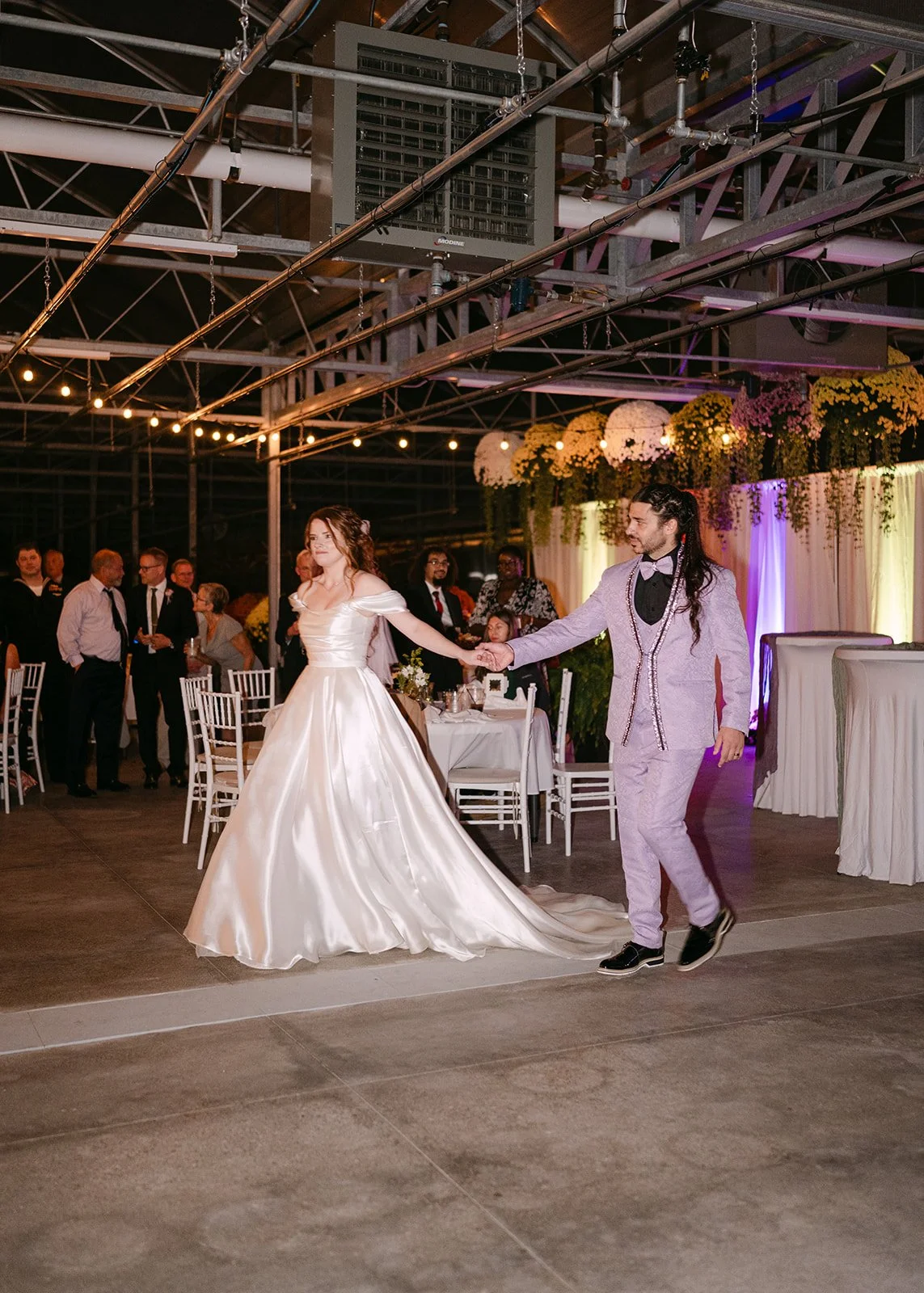 Bride and g room walking to the center of the room for their first dance.