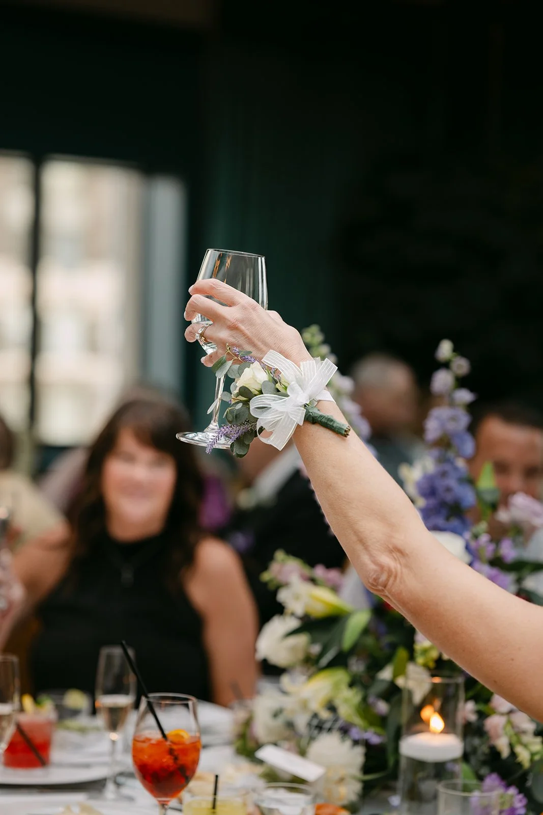 Guest raising a glass during speeches inside The Conservatory at Book Tower in Detroit.