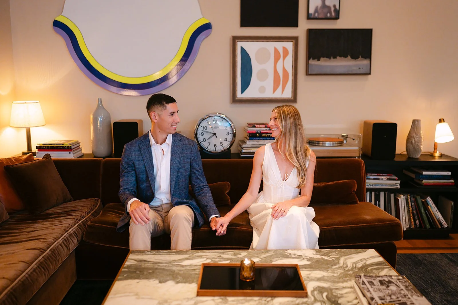 Couple holding hands and sitting inside Shinola Hotel.