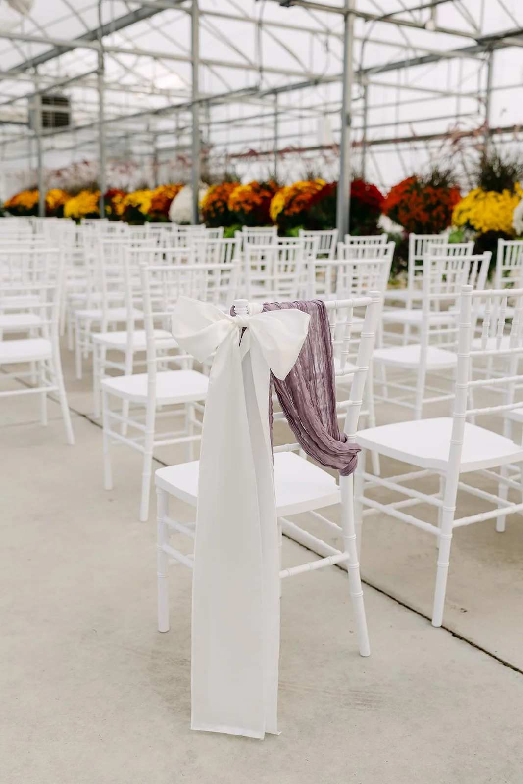 Ribbon tied chair decor from an Abele Greenhouse wedding ceremony in Saginaw, Michigan.
