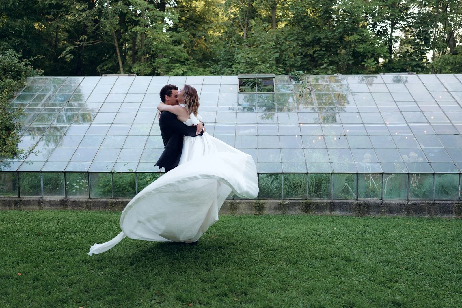 A bride being spun in the air by her groom at Glass House Creative Community Michigan.