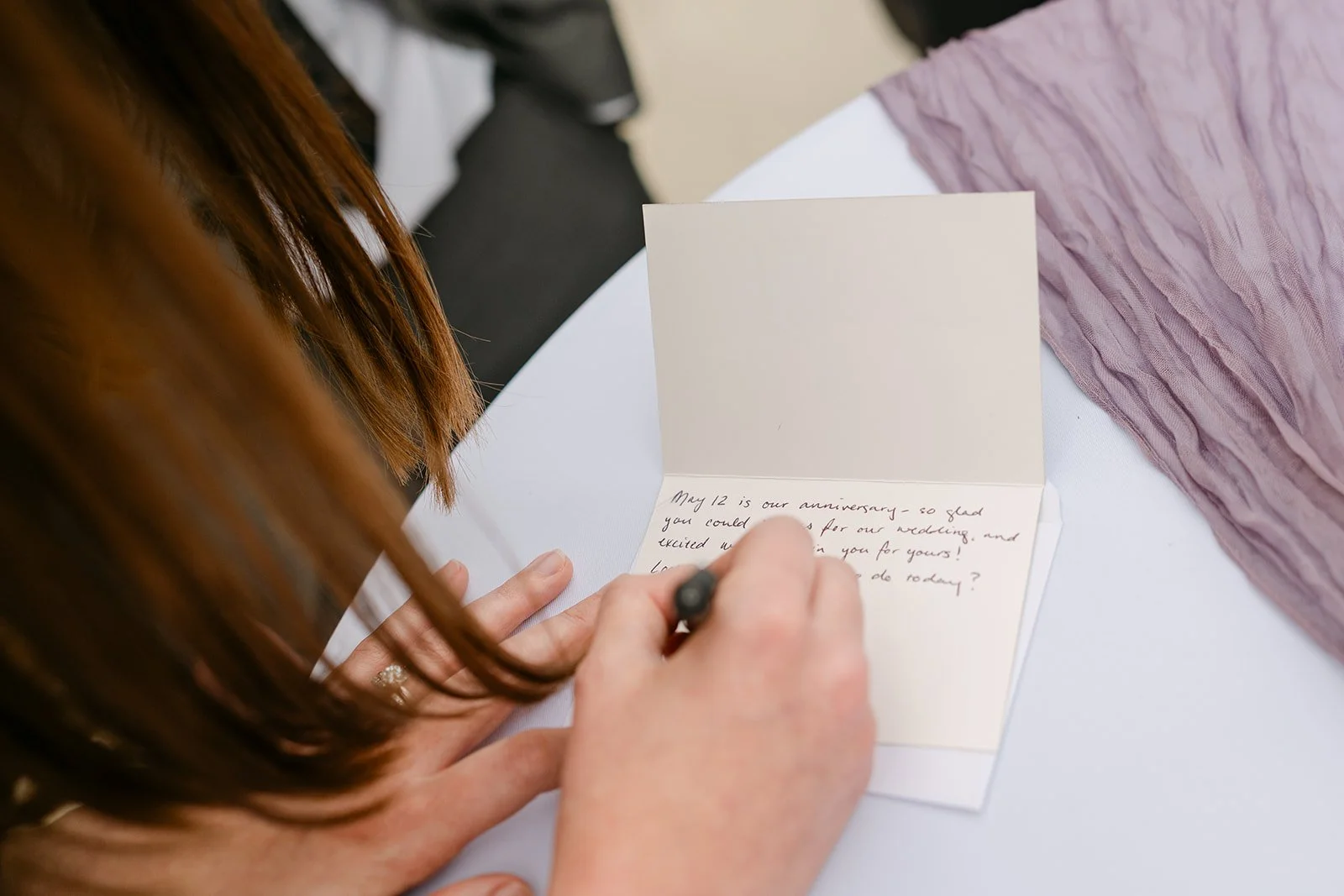 Guest writing a note to the bride and groom during cocktail hour.