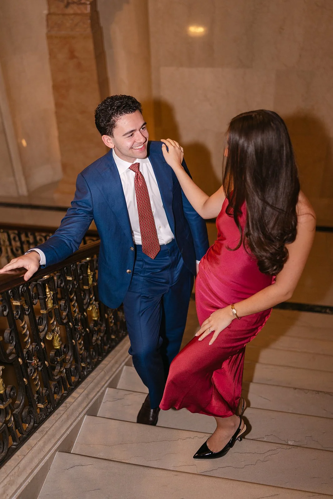 Bride and groom smiling and walking up the staircase at The Detroit Athletic Club.