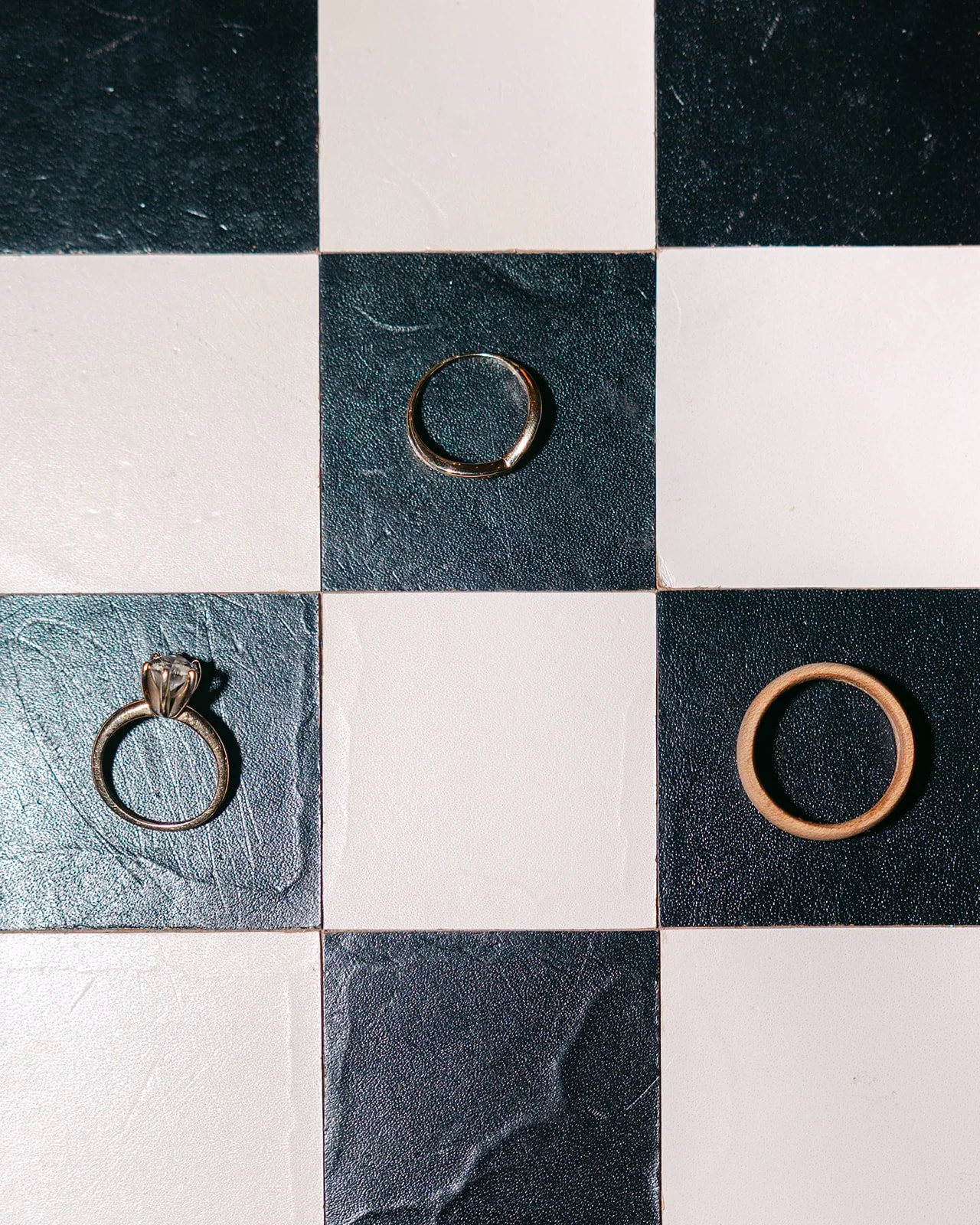 Wedding rings and band styled on a checkered floor at Book Tower.
