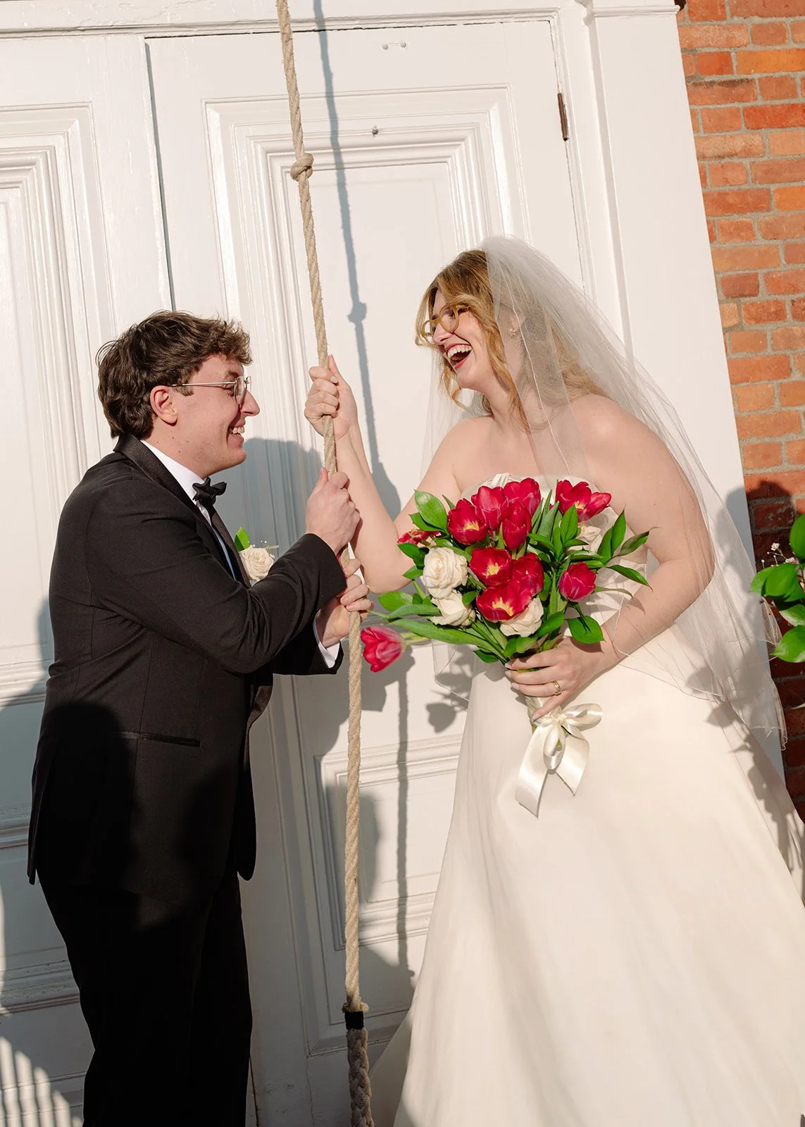 Bride and groom ringing the bell after their Martha-Mary Chapel wedding ceremony at Greenfield Village.