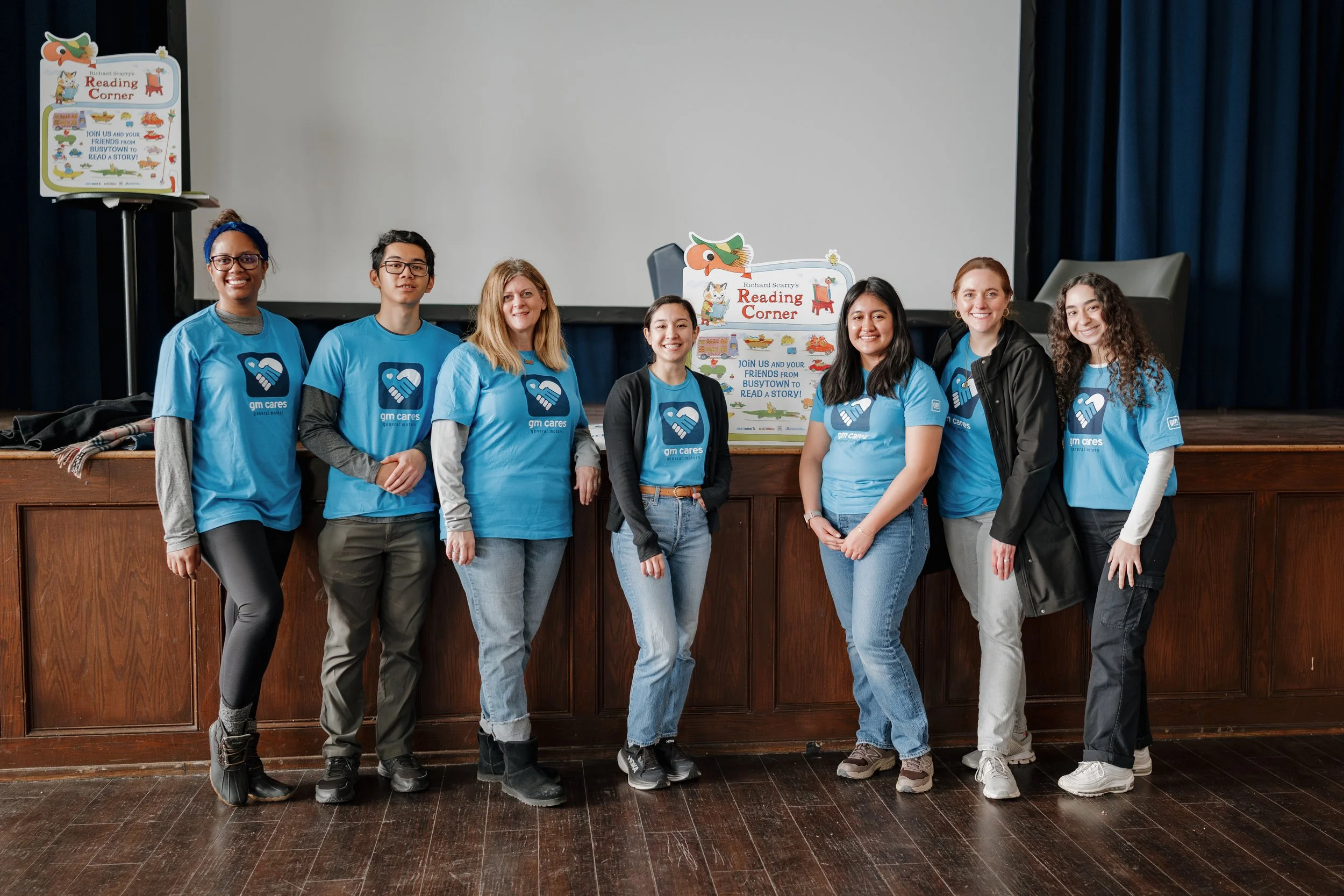 a photo of a volunteer team at a book event in Detroit Michigan. They wear blue GM Cares shirts.