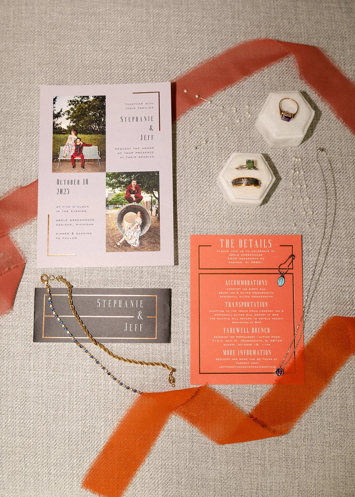 Flatlay of wedding details with invites, jewelry, rings, and more.