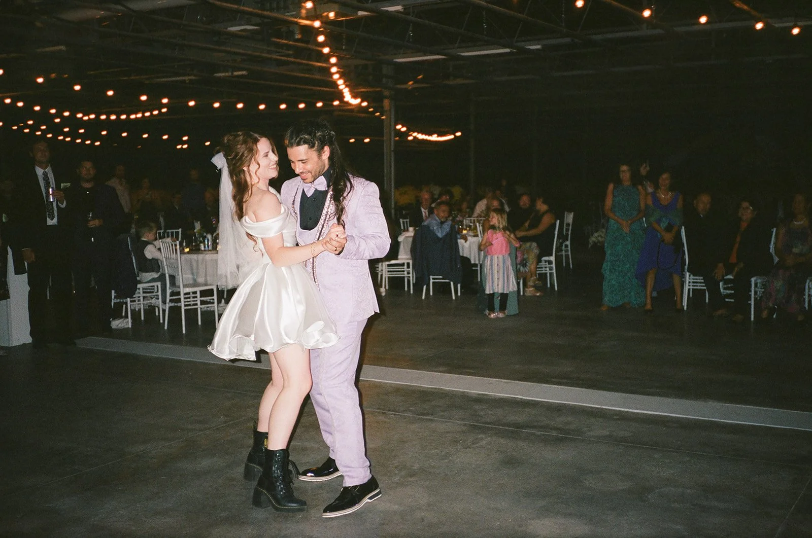 Film photo of the bride and groom dancing.