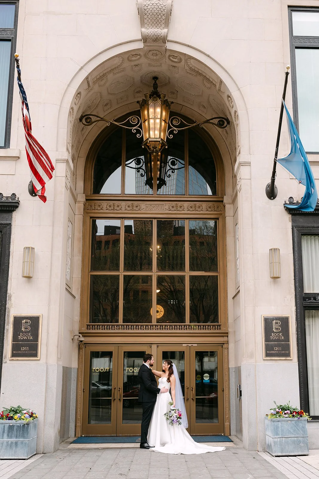 Bride and groom posing together outside of Book Tower in Detroit, MI.