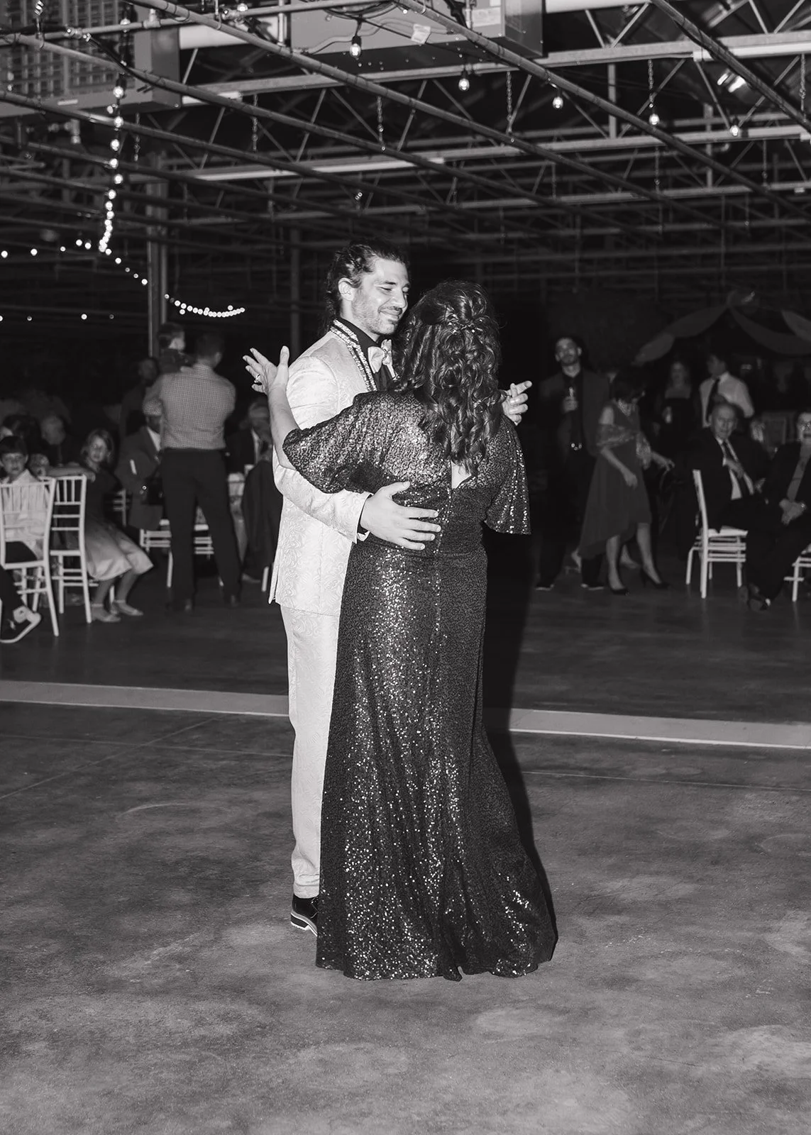 Black and white photo of the groom dancing with his mother.