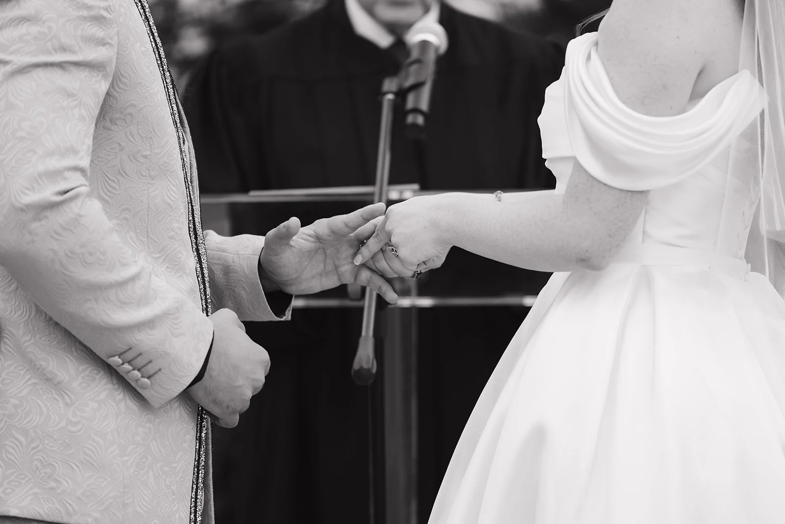 Bride and groom exchanging rings during Abele Greenhouse wedding ceremony in Saginaw, Michigan.