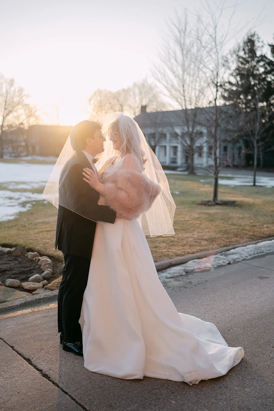 Golden hour wedding photo of couple posing outside of Greenfield Village in Dearborn for their winter wedding portrait.