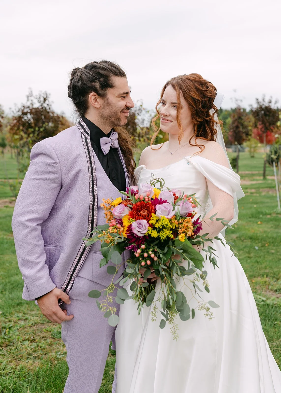 Bride and groom smiling at each other at Abele Greenhouse in Saginaw, Michigan.