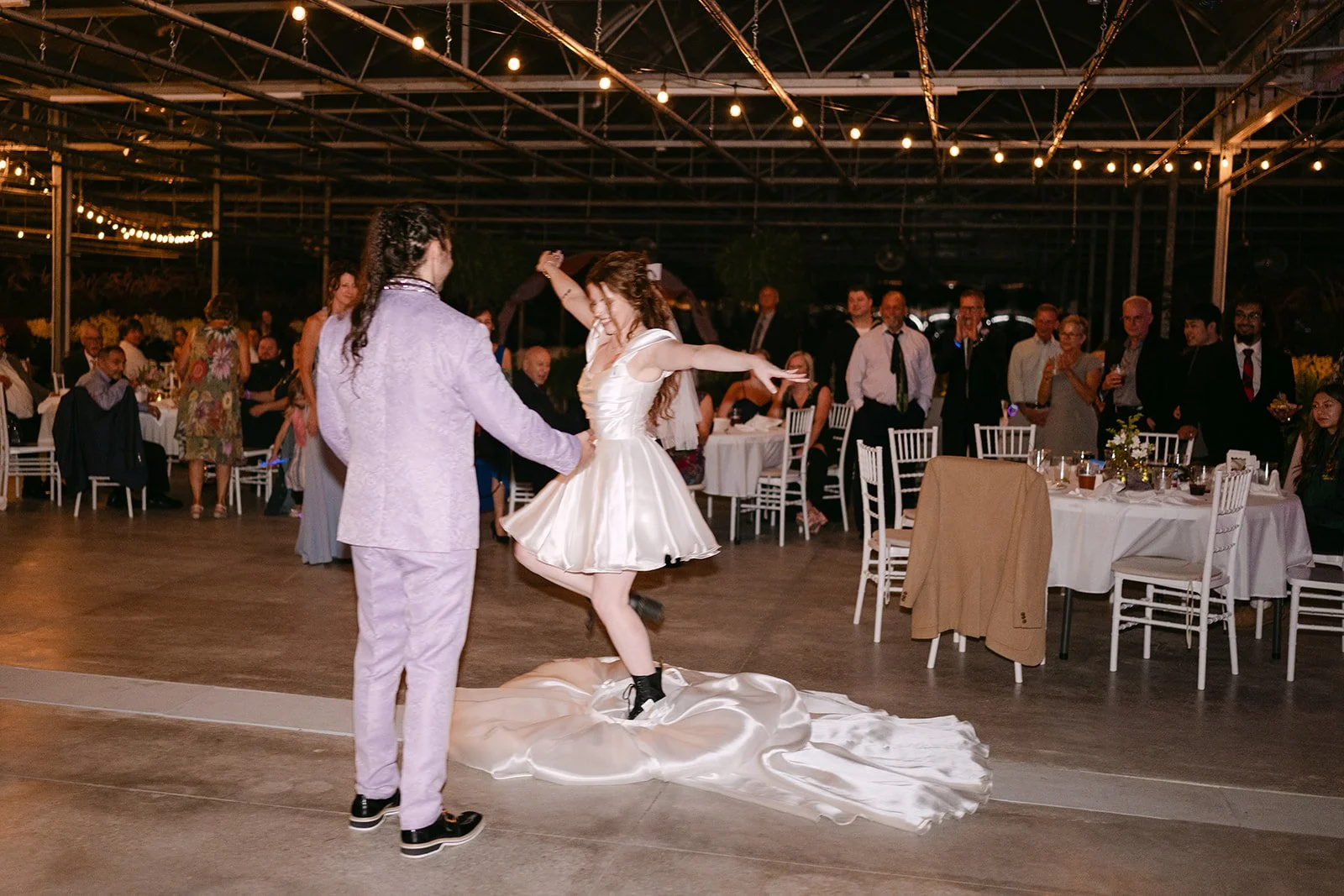 Bride surprising the groom during their first dance with a split dress.