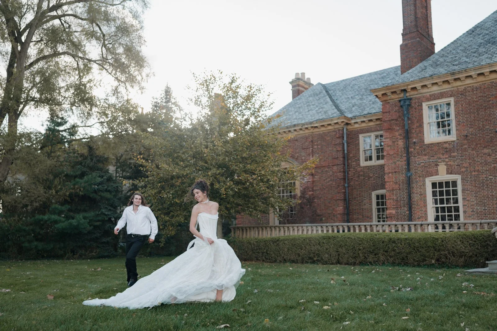 A playful photo of a groom chasing his ethereal bride across the grounds of the Clairwood Estate wedding venue