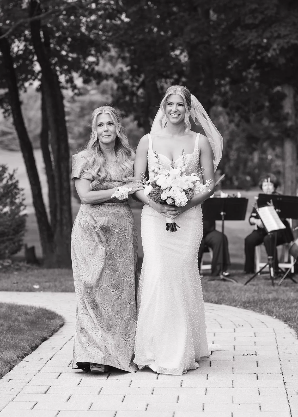 A bride walking down the aisle with her mom.