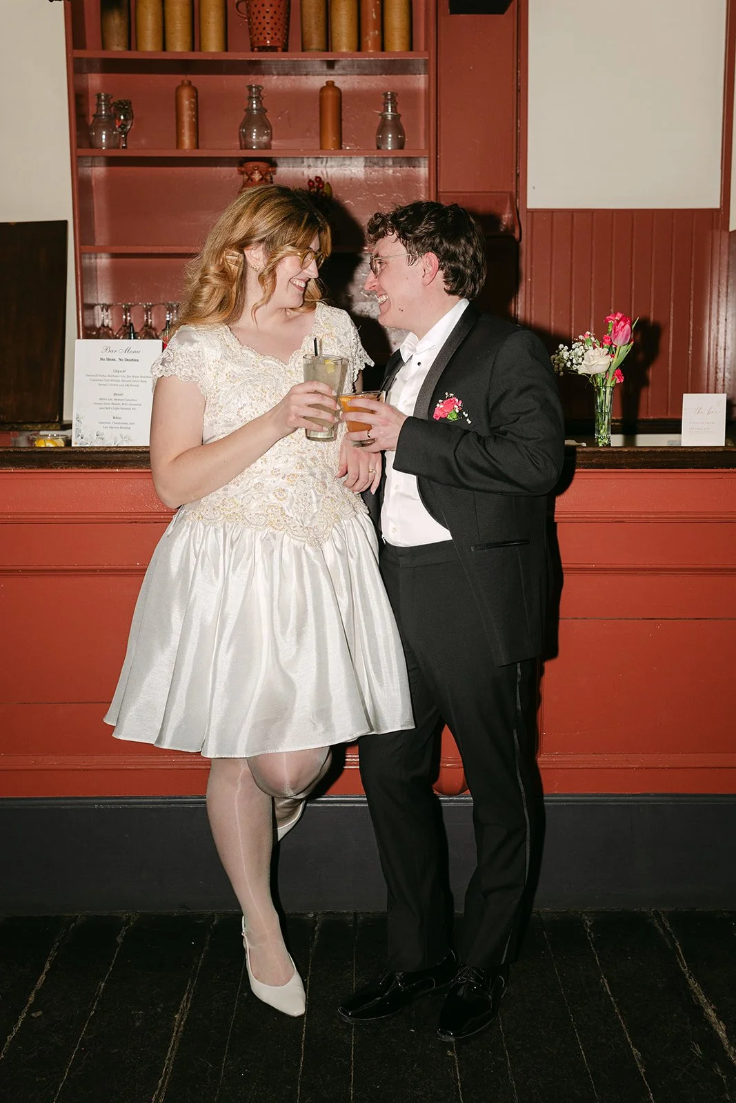Bride and groom posing with their drinks during their Greenfield Village wedding reception at Eagle Tavern.