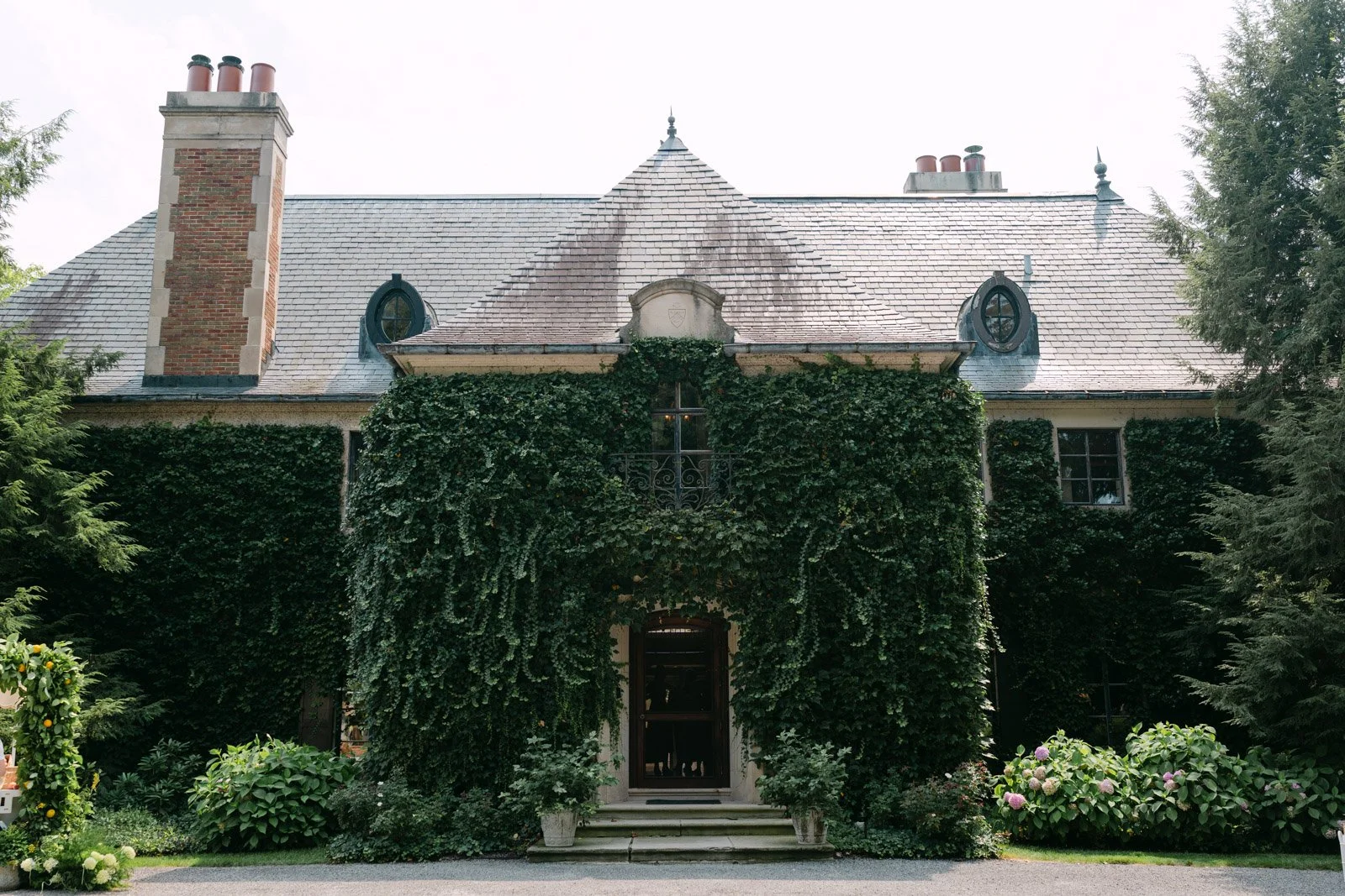 An exterior photo of Greencrest Manor, one of the best estate wedding venues in Michigan because of it's grandeur, french-inspired architecture and garden grounds.