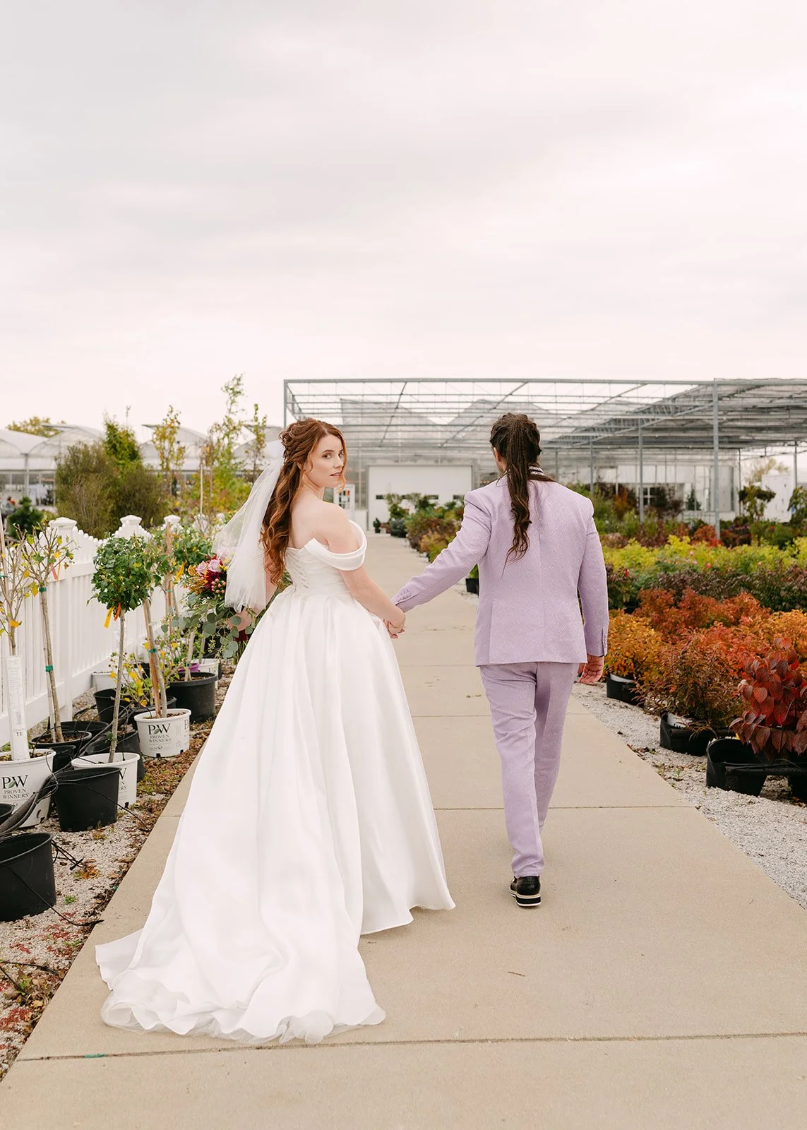 Bride and groom walking to Abele Greenhouse in Saginaw, Michigan.