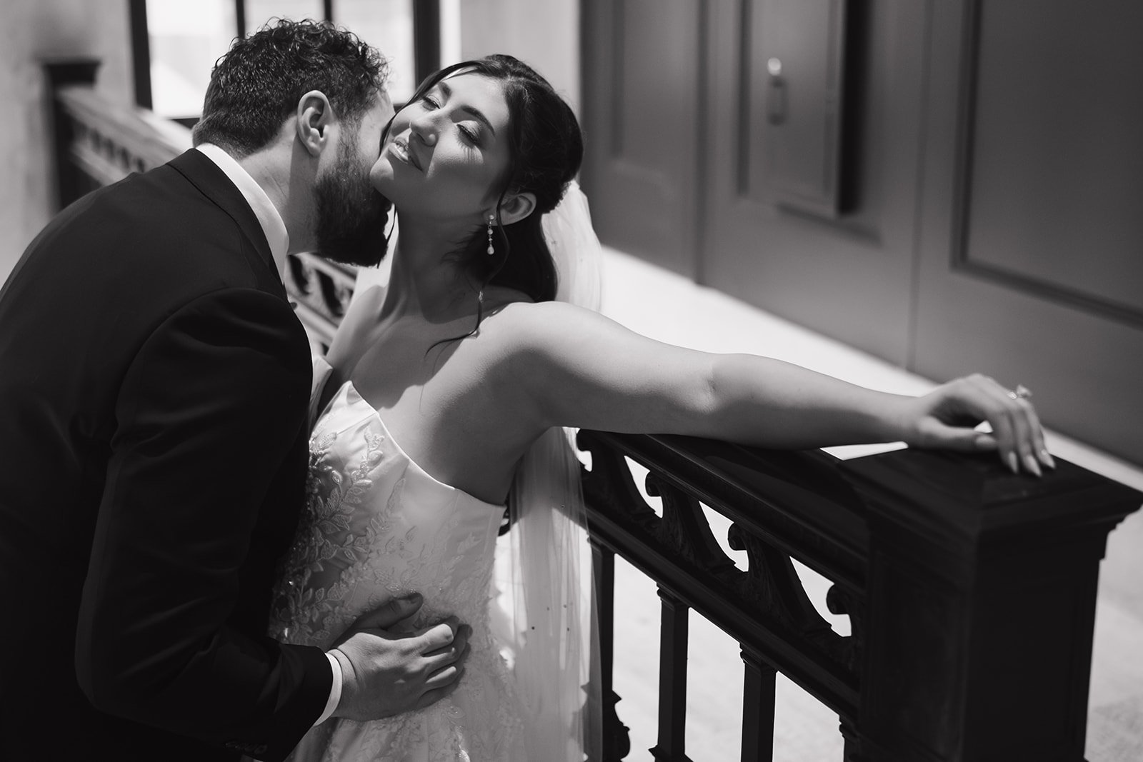 Intimate black and white photo of the groom kissing the brides neck on the second floor of Book Tower in Detroit.