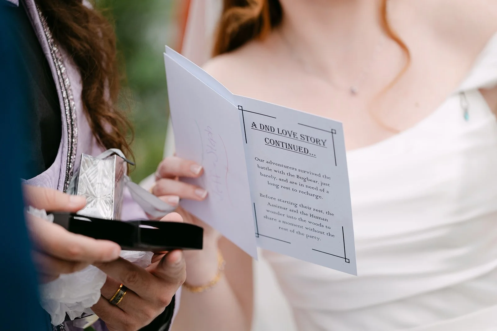 Bride and groom opening a custom dungeons and dragons dice gift from friends.