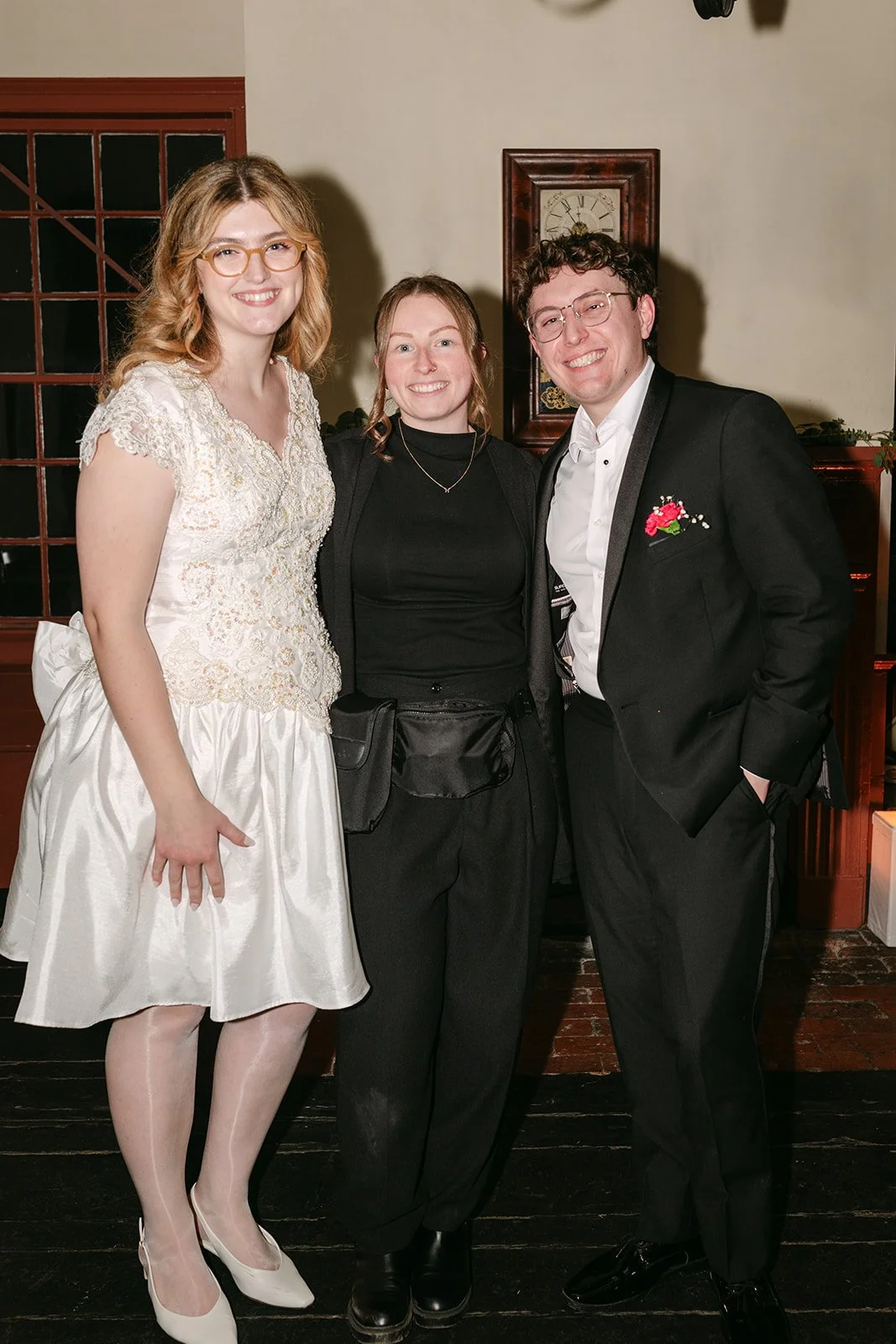 Alaina, wedding photographer, posing with the bride and groom.