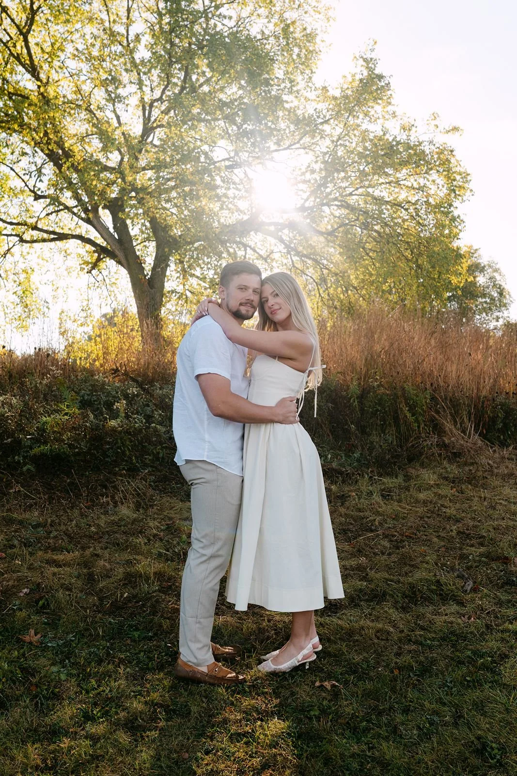 A newly engaged couple posing for a fall portrait at their engagement photos in Michigan.