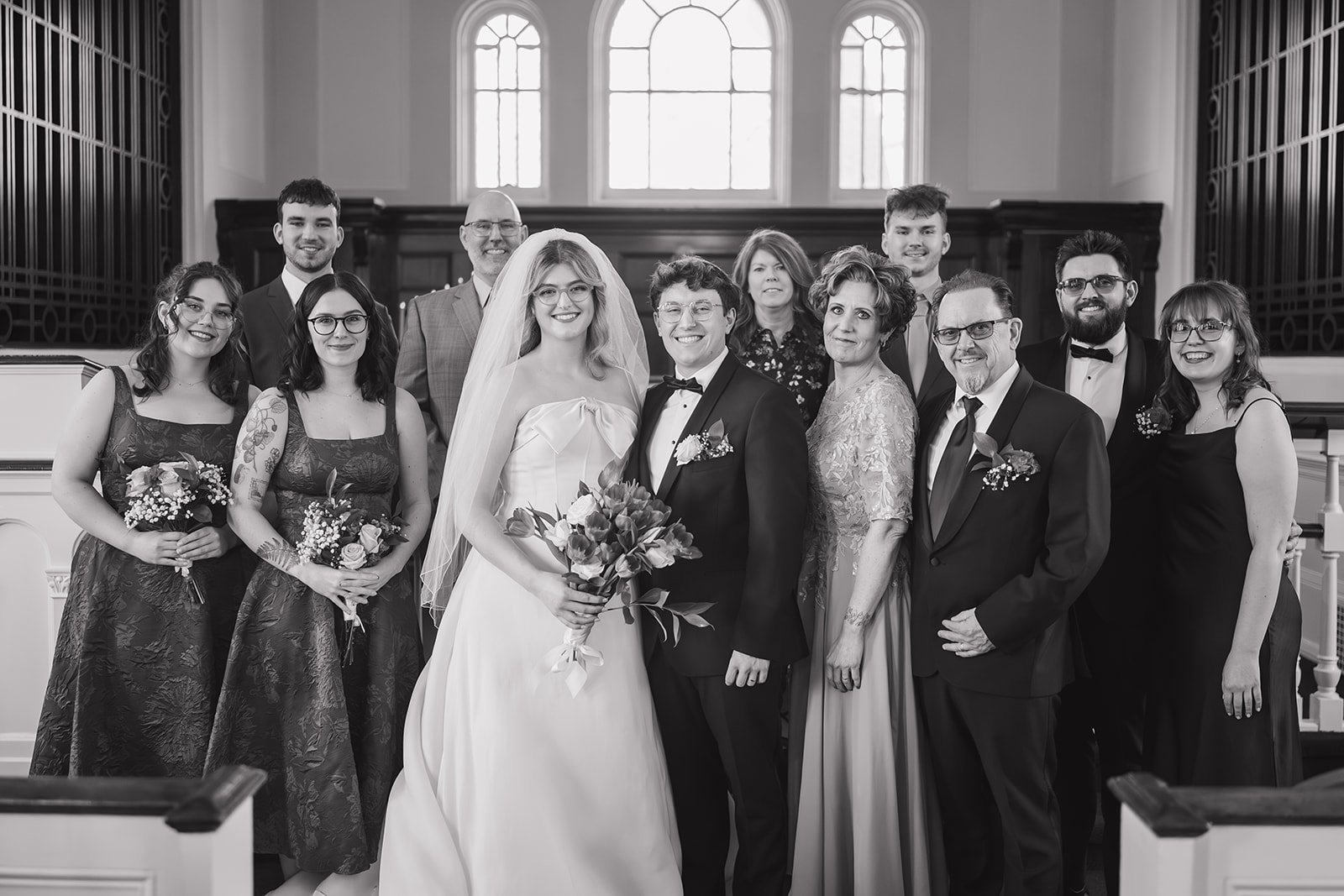 Black and white photo of family posing with the bide and groom inside Martha-Mary Chapel in Dearborn.