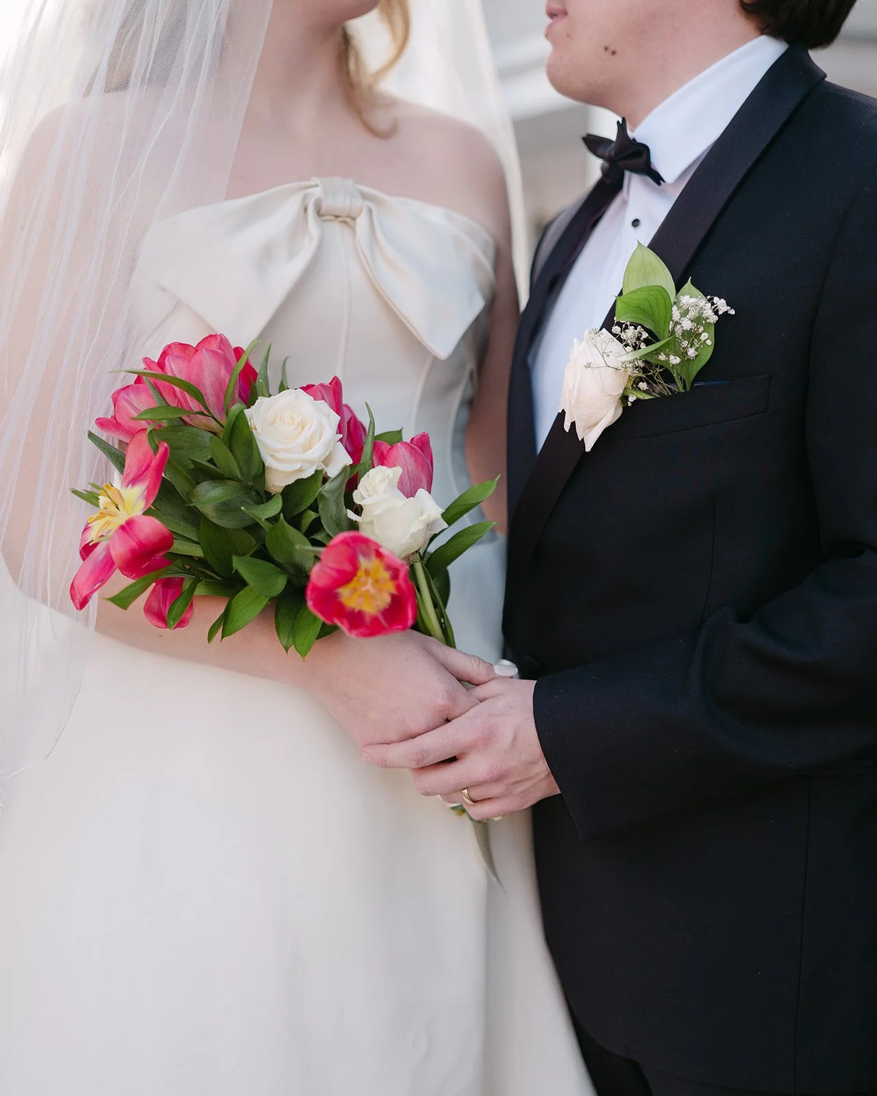 Close up of a bride and groom posing next to each other.