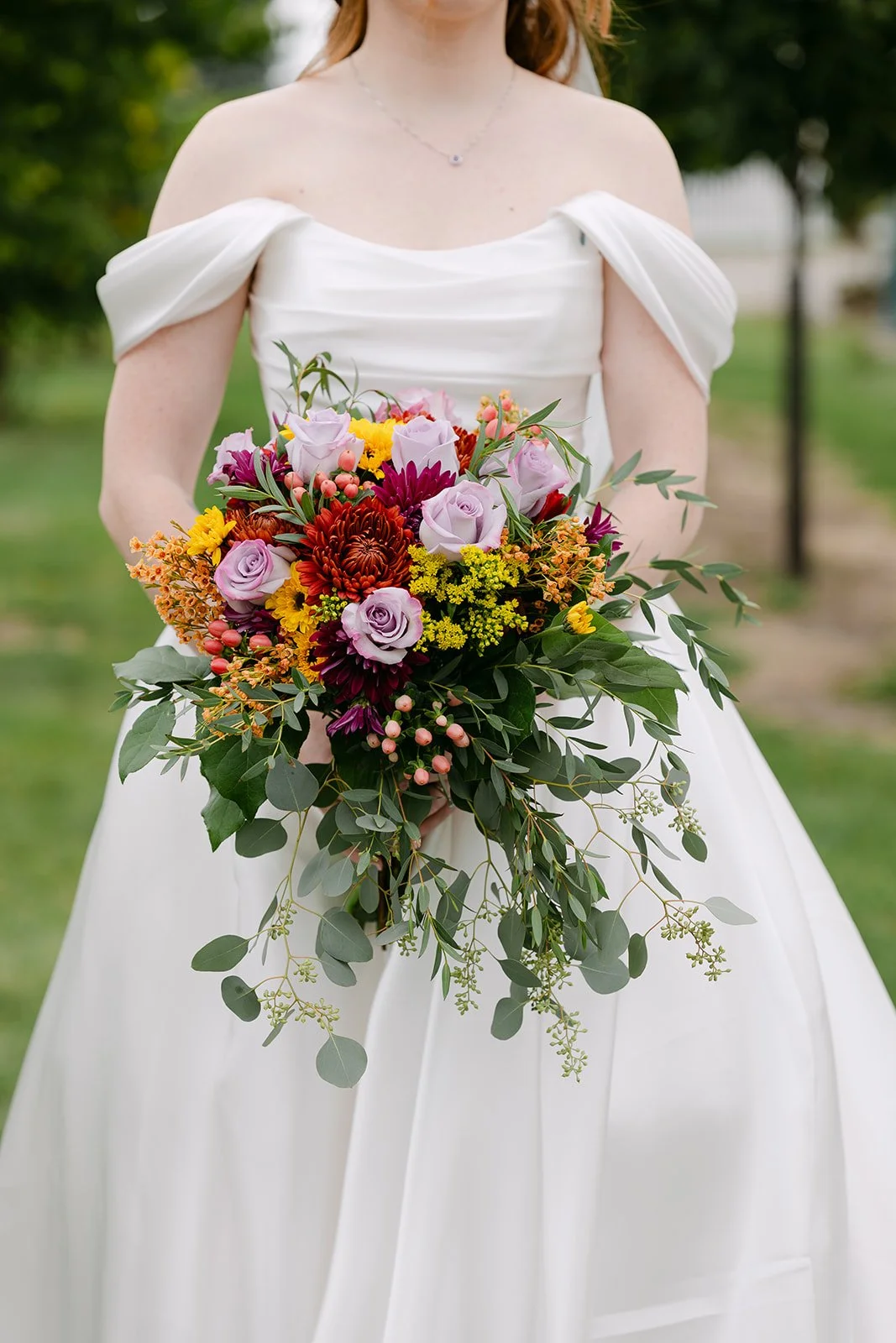 Close up shot of the bride holding her colorful wedding bouquet.