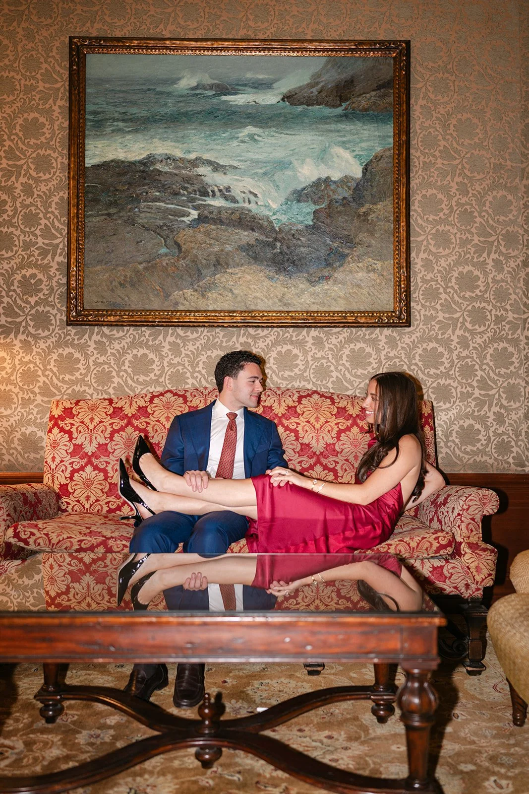 Flash photo of a woman resting her legs on her fiancés lap inside the DAC for their engagement session.