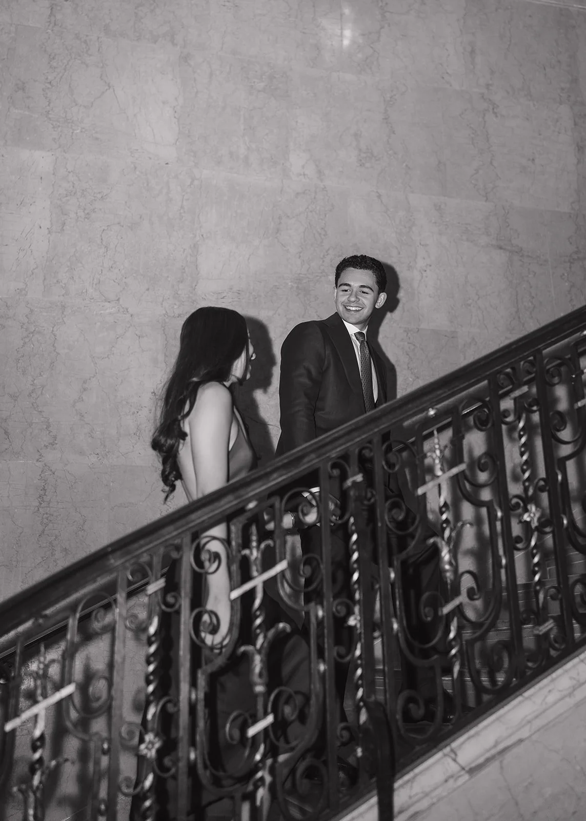 Flash black and white photo of a couple walking up the stairs inside Detroit Athletic Club.
