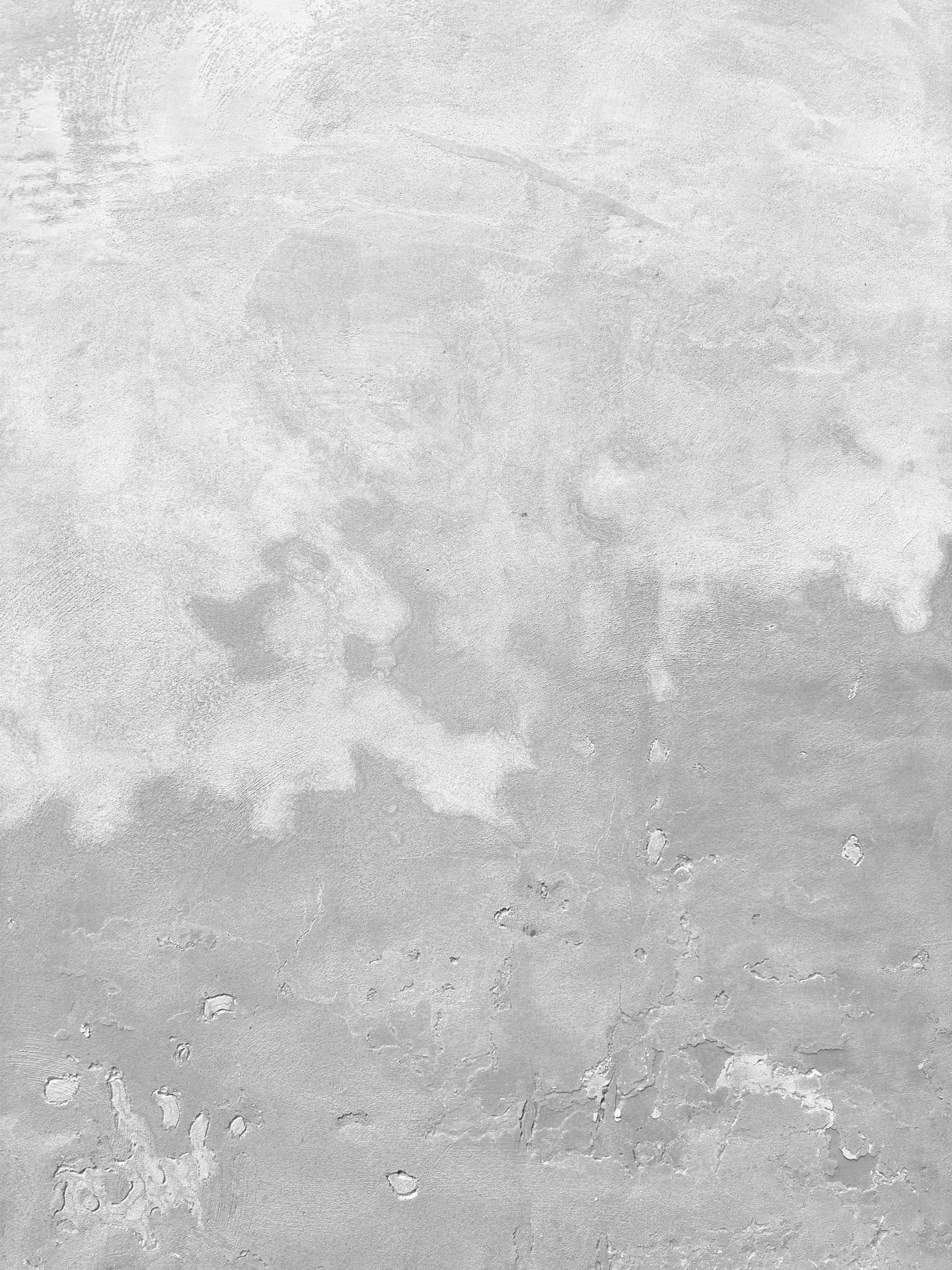 Close-up of a textured concrete surface with cracks and small holes.