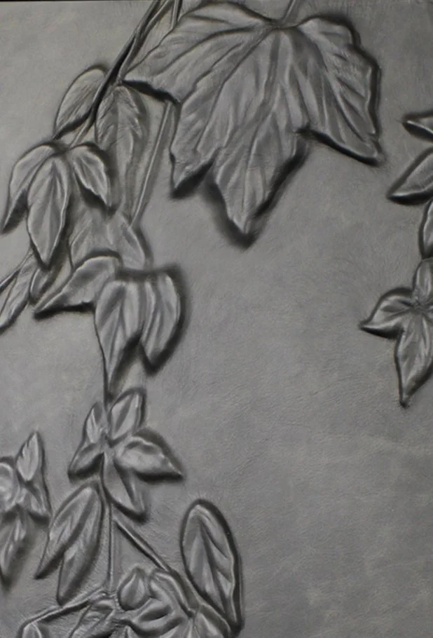 an earthy toned botanical leather bas relief style wall covering of ivy leaves trailing by Marrikur Studios