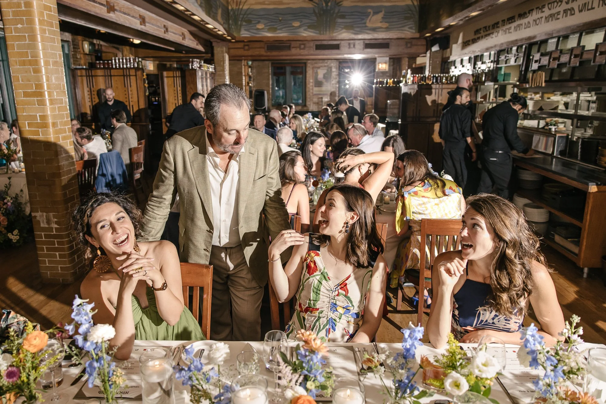 Father of the bride talking with wedding guests and laughing