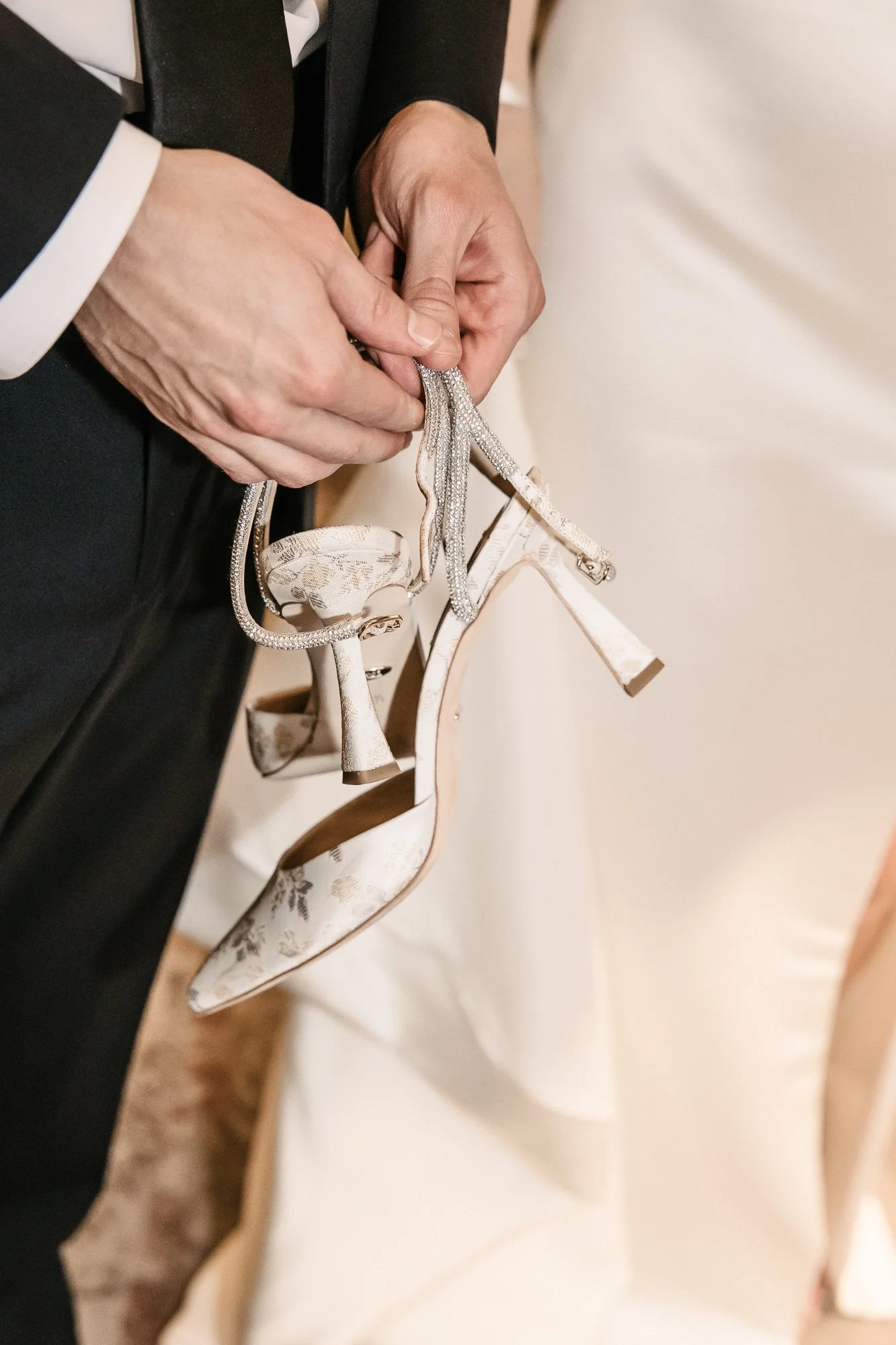 Groom holding brides shoes, just after wedding. Close-up photo of bride and groom at The Pfister Hotel