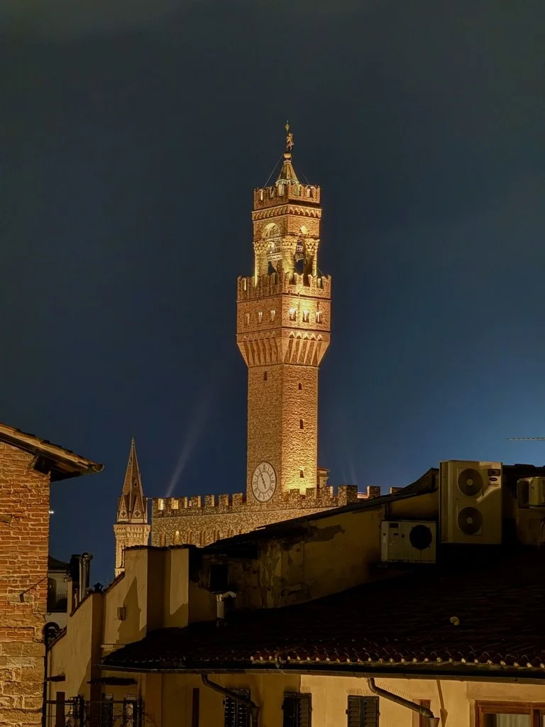 Nighttime view of the Torre d'Arnolfo, near the Palazzo Vecchio and Ponte Vecchio in Florence.