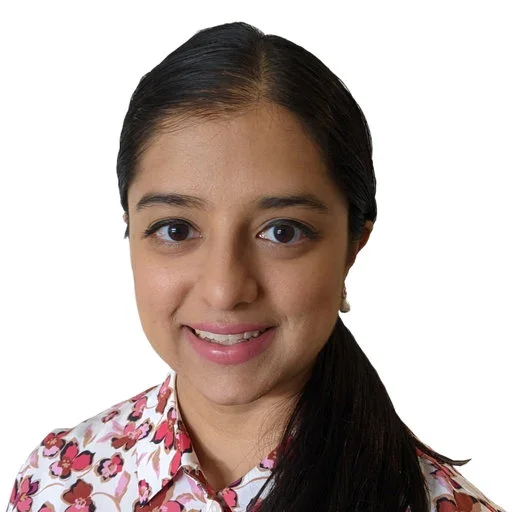 Portrait of a woman with long dark hair, smiling, wearing a floral blouse