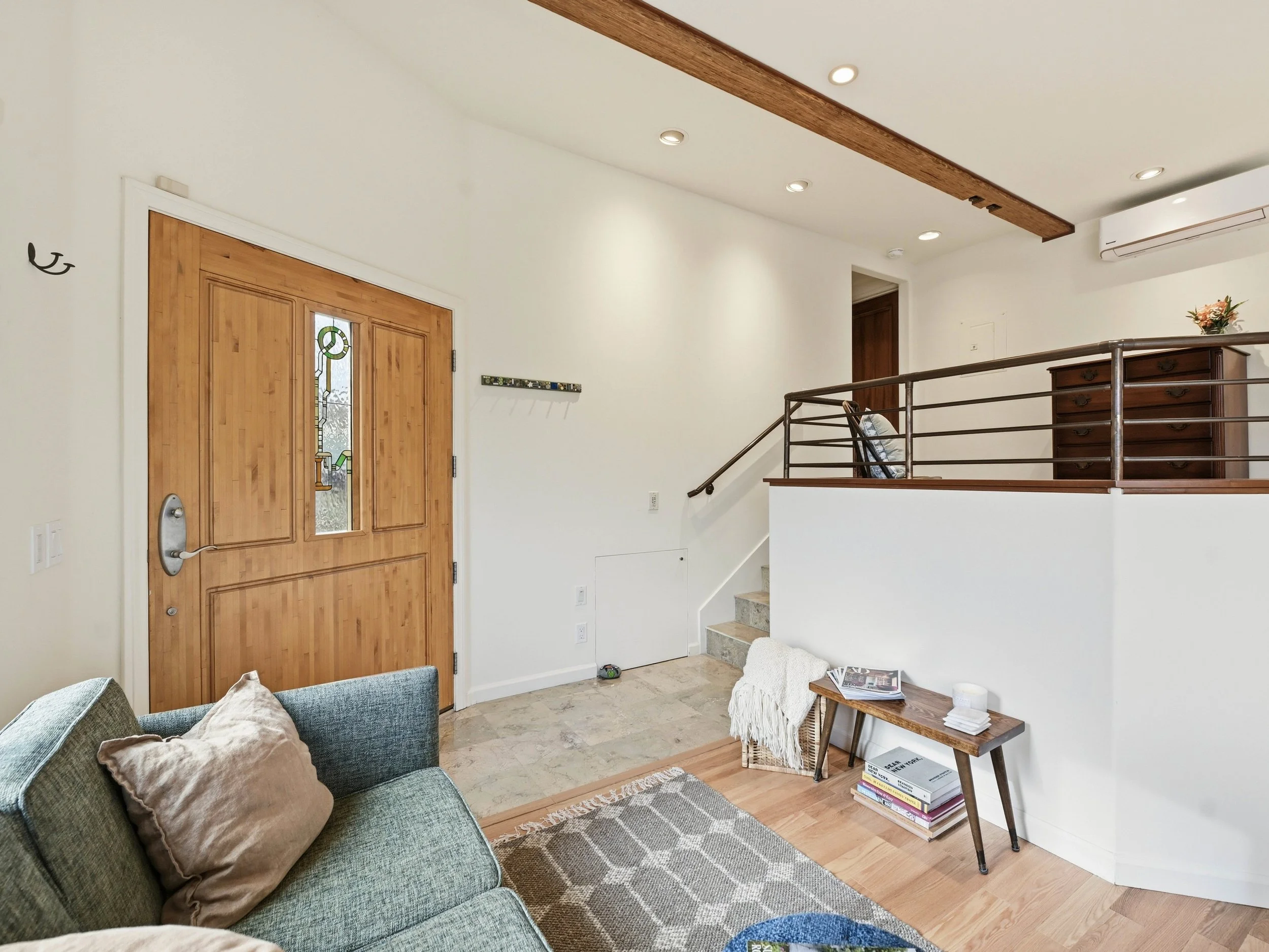 Photograph of an ADU studio unit. View of living room and front door. Furnished rental unit ready for move in.