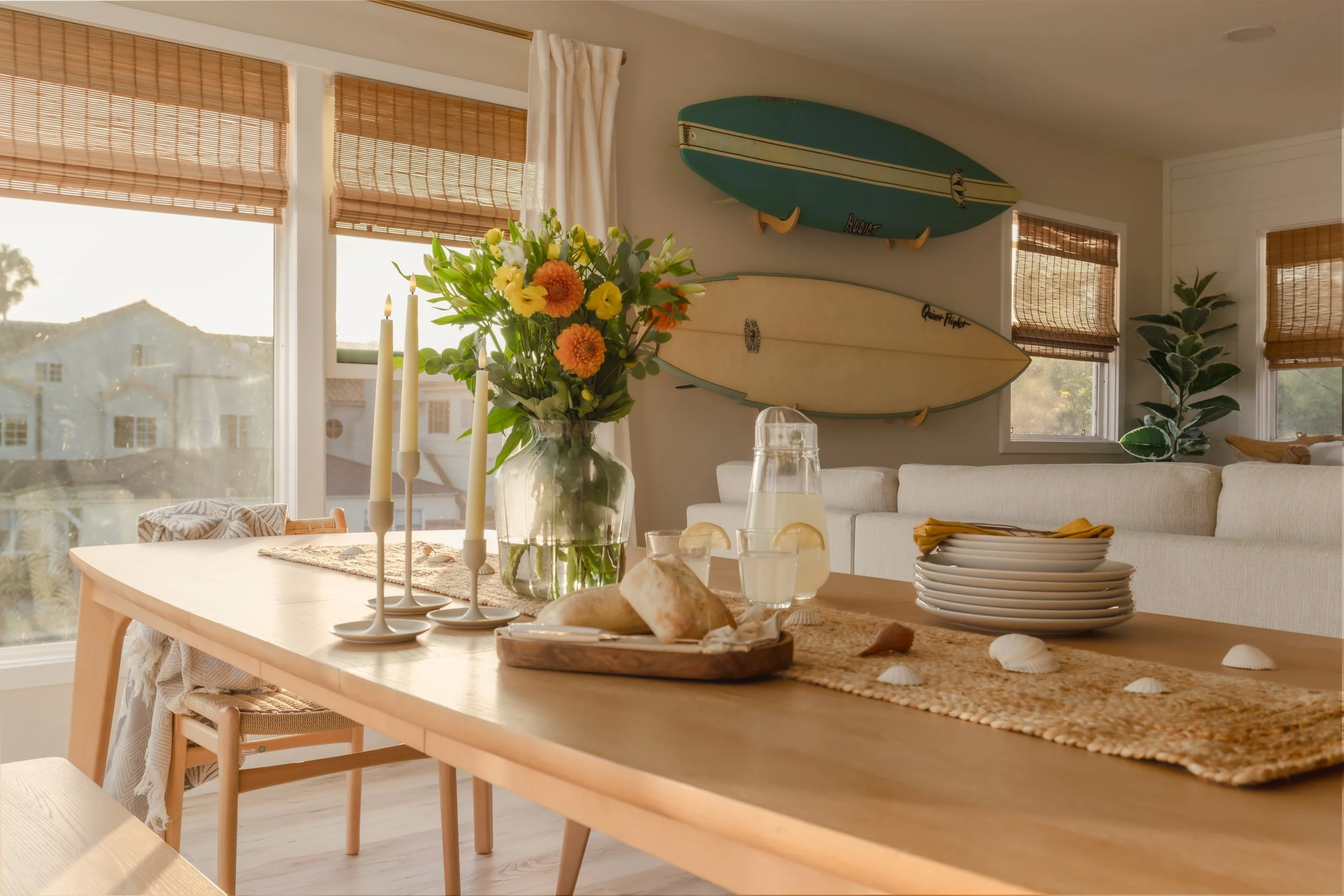Photograph of the interior design and decorating of a coastal dining room with bamboo blinds and surf boards