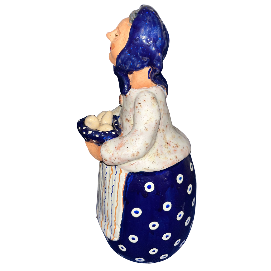Hand-painted folk art babcia grannie figurine holding a bowl of fresh eggs