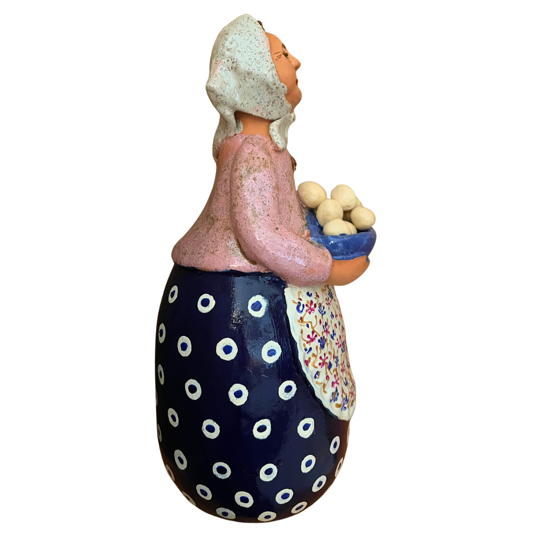 Hand-painted folk art babcia grannie figurine holding a bowl of fresh eggs