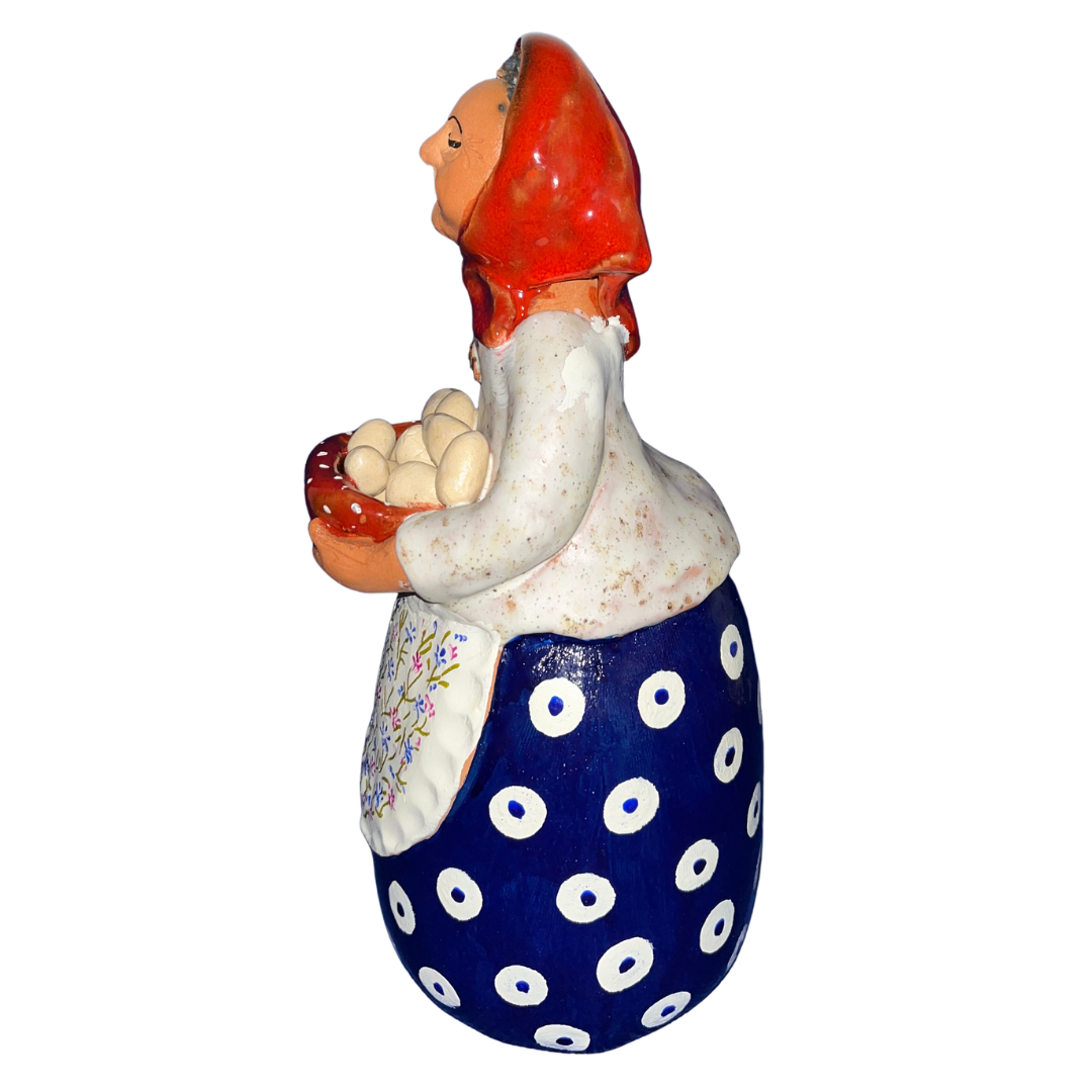 Hand-painted folk art babcia grannie figurine holding a bowl of fresh eggs