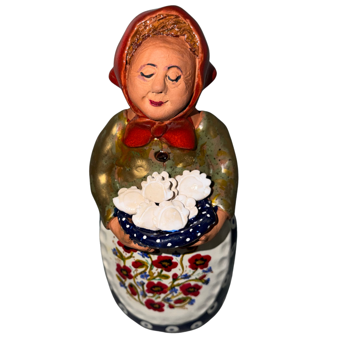 Hand-painted handcrafted babcia figurine holding a bowl of pierogi.