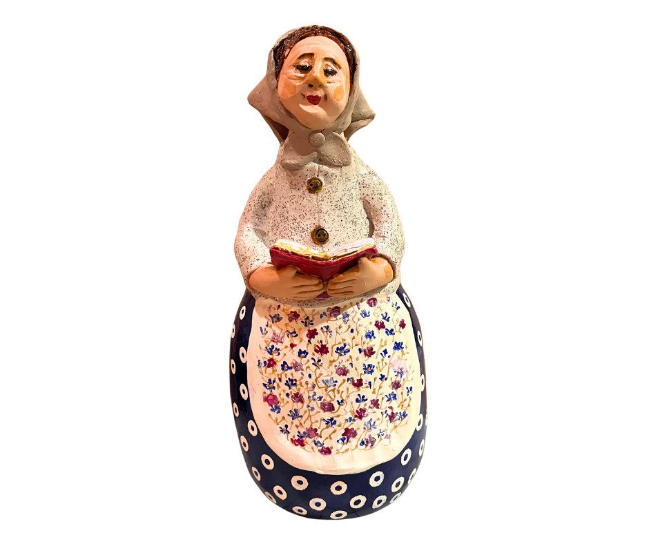 Charming hand-painted “Babcia Holding a Book” figurine featuring a Polish grandmother in an aqua scarf and floral apron. A heartwarming gift and beautiful piece of folk-inspired home décor.
