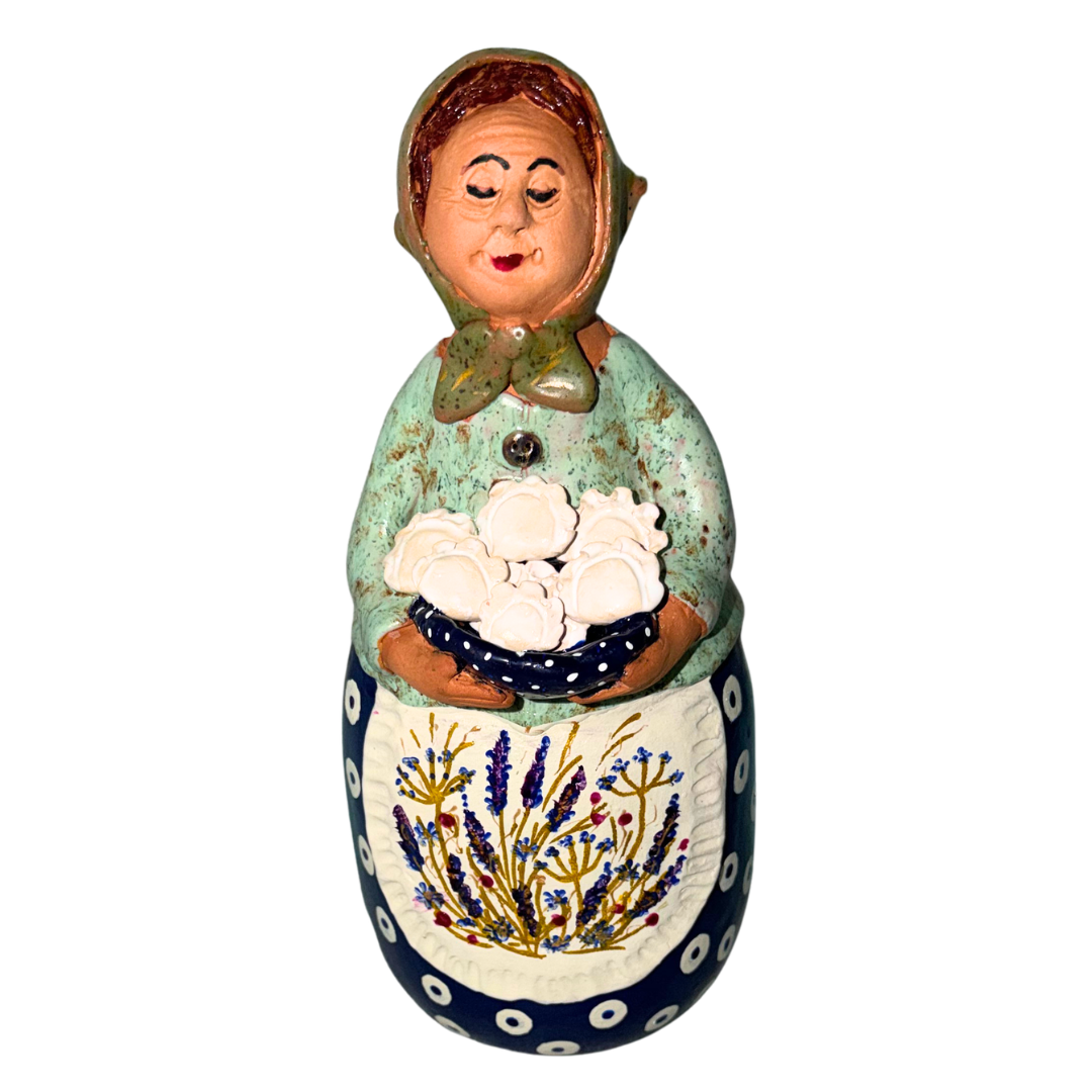 Hand-painted handcrafted babcia figurine holding a bowl of pierogi.