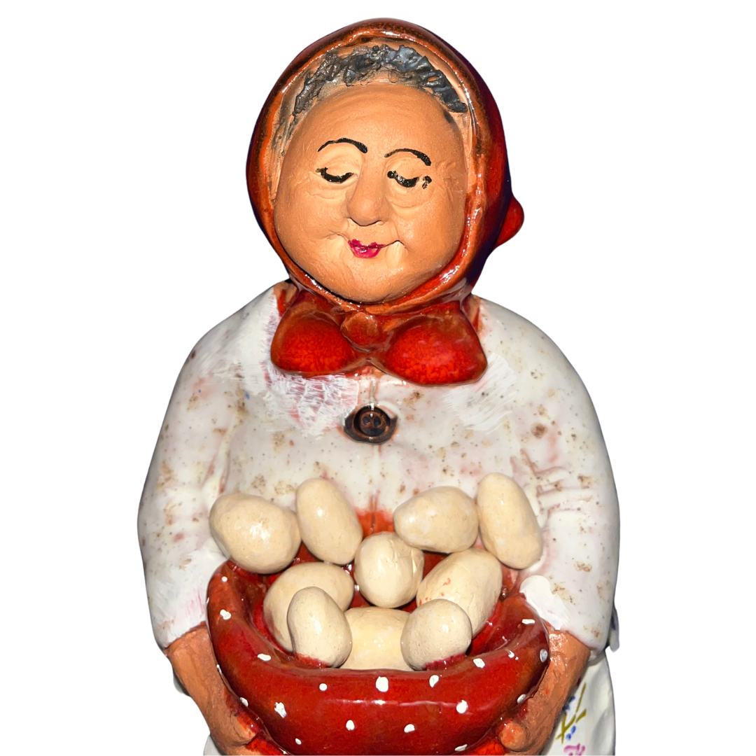 Hand-painted folk art babcia grannie figurine holding a bowl of fresh eggs