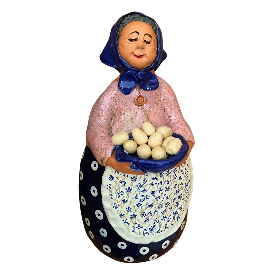 Hand-painted folk art babcia grannie figurine holding a bowl of fresh eggs