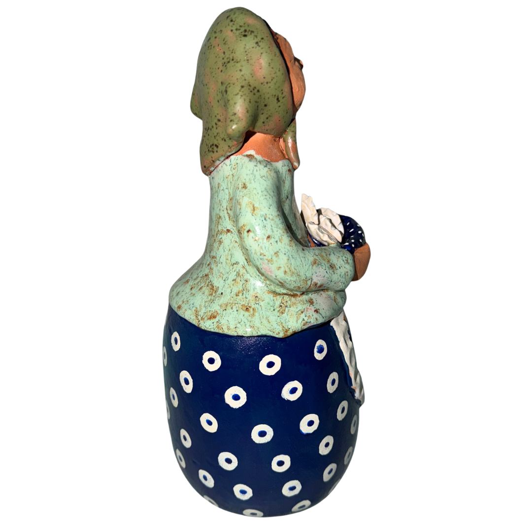 Hand-painted handcrafted babcia figurine holding a bowl of pierogi.